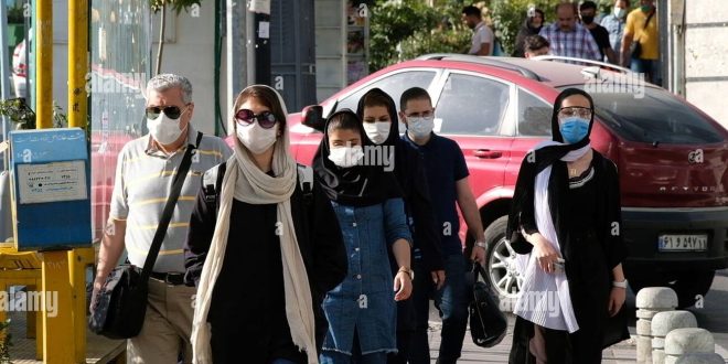 iranian-people-wearing-protective-face-masks-walk-along-an-avenue-in-northern-tehran-following-the-new-coronavirus-covid-19-